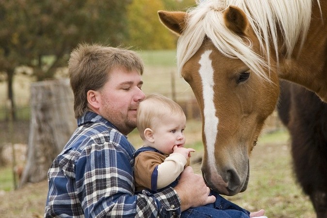 Vader met baby op kinderboerderij