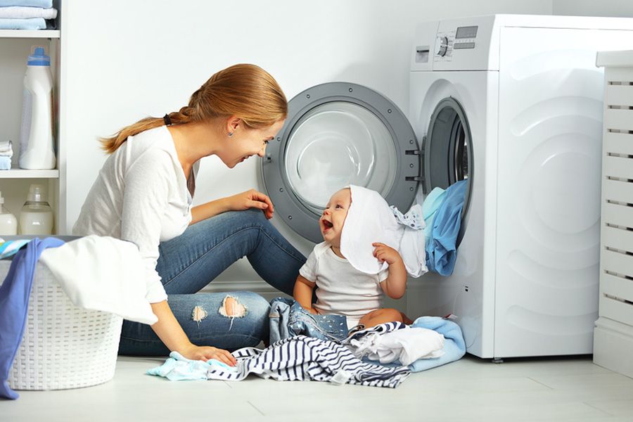 baby van 13 weken oud speelt met de kleding van zijn moeder