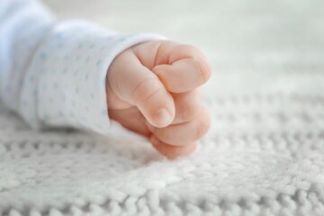 babygebaren van een pasgeboren baby die zijn handje tot een vuist maakt