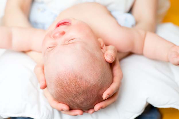 Moeder pakt baby voor nachtvoeding tijdens weer een gebroken nacht