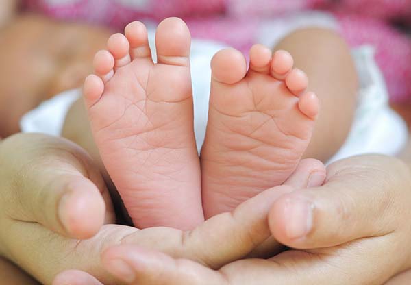 Babyvoetjes in de handen van haar moedern