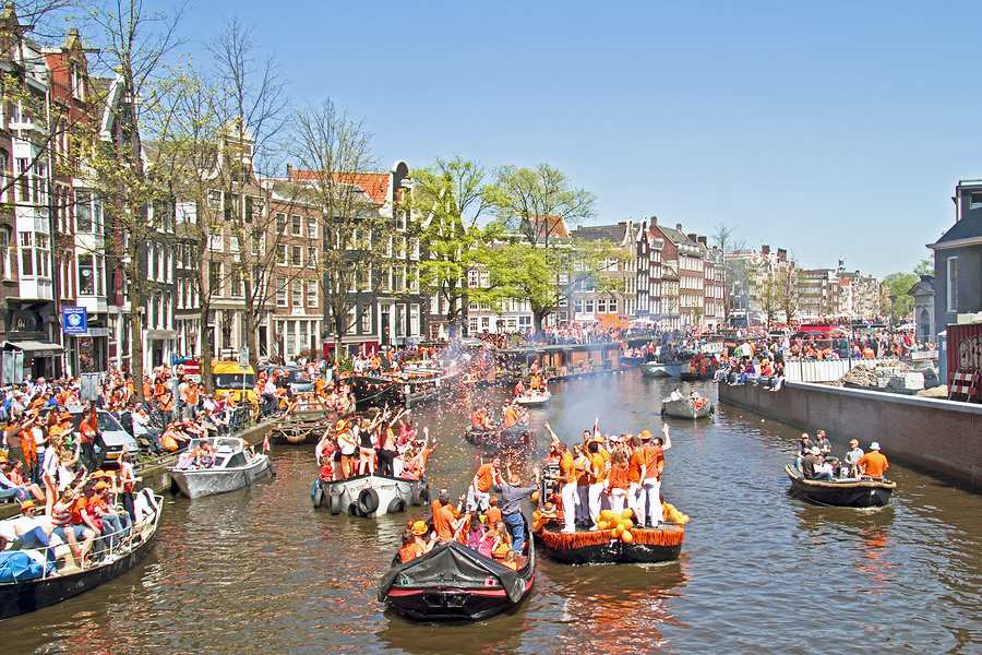 Viering Koningsdag op bootjes in de Amsterdamse grachten