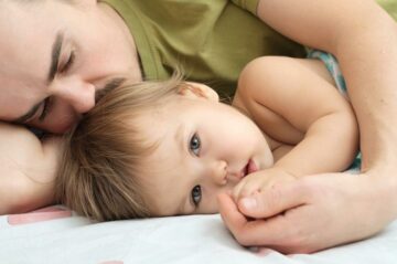 Vader ligt met baby na koortsstuip