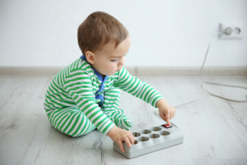 Baby speelt met stekkerdoos