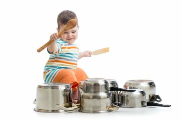 Baby-drumt-op-pannen-met-pollepel.-Baby-7-maanden-compressor