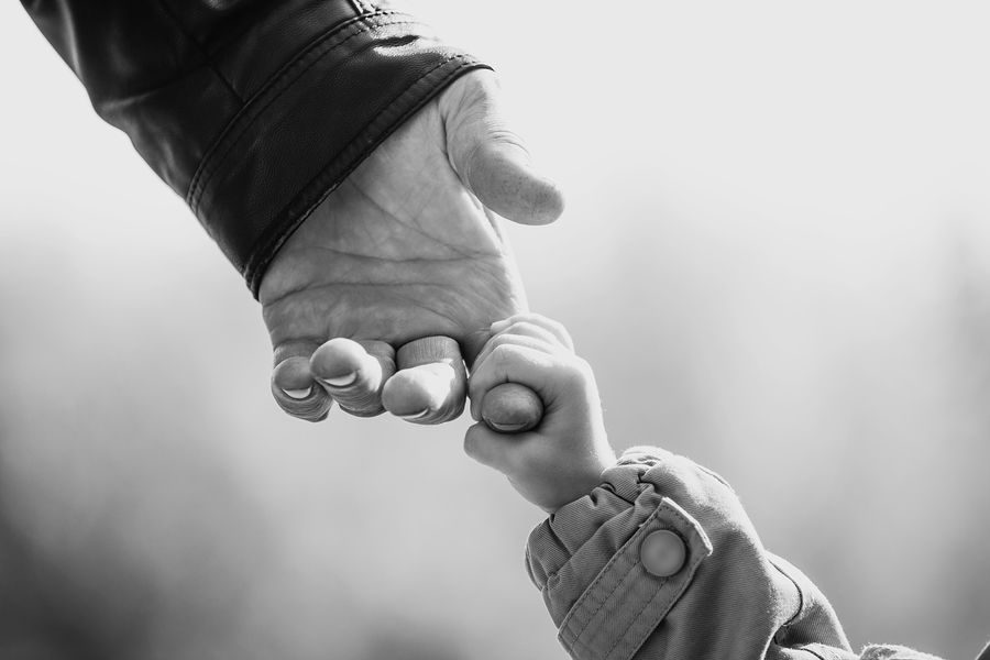 close-up-van-handje-peuter-die-hand-opa-vasthoudt