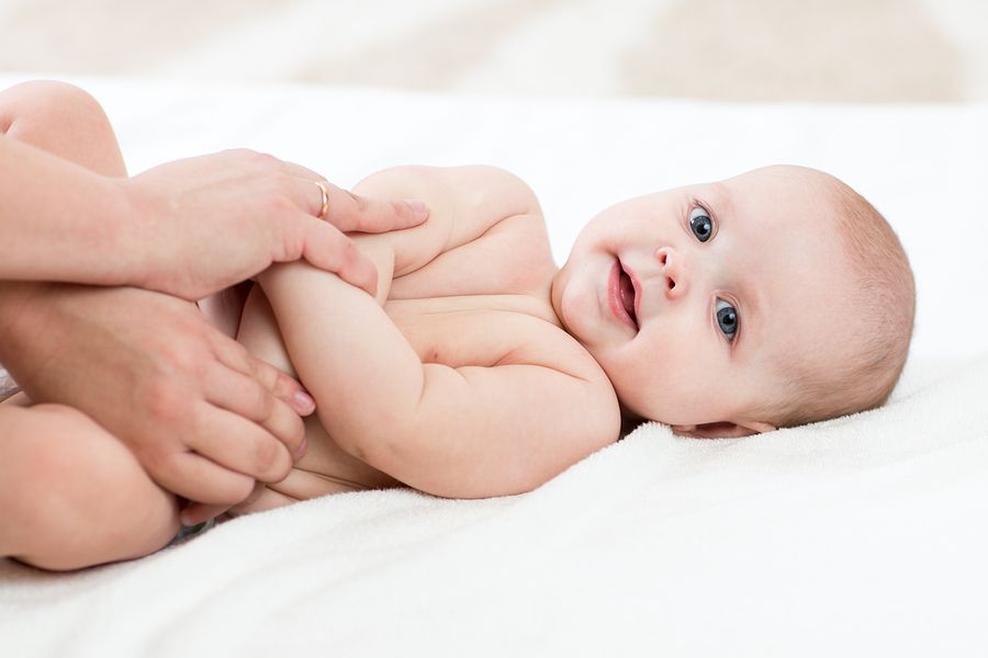 Moeder traint en rekt de armpjes van baby van 14 weken oud