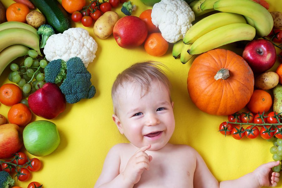 Baby-van-20-weken-oud-ligt-tussen-allerlei-verschillende-soorten-groente-en-fruit