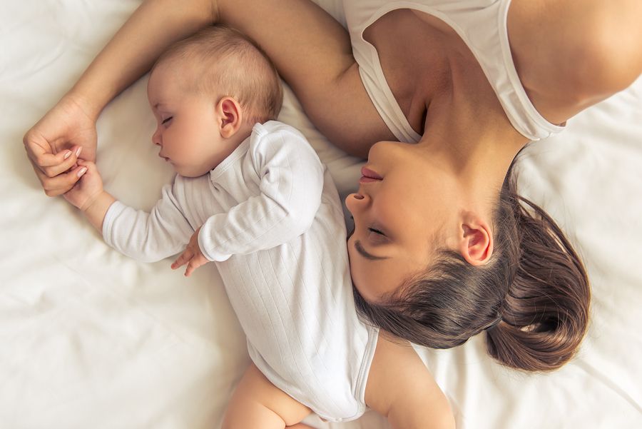 Moeder en baby van 22 weken oud liggen samen te slapen