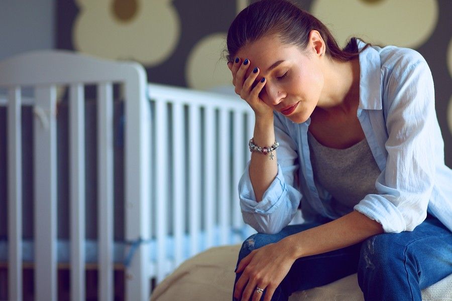 Uitgeputte jonge moeder van baby van 23 weken oud