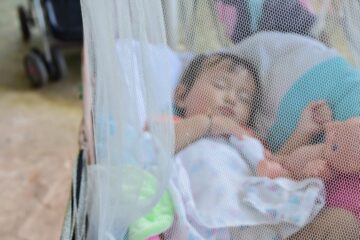 baby slaapt buiten onder muskietennetje tegen insecten