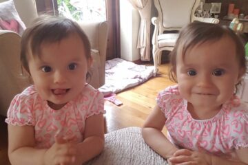 Tweeling meisjes met roze jurkjes