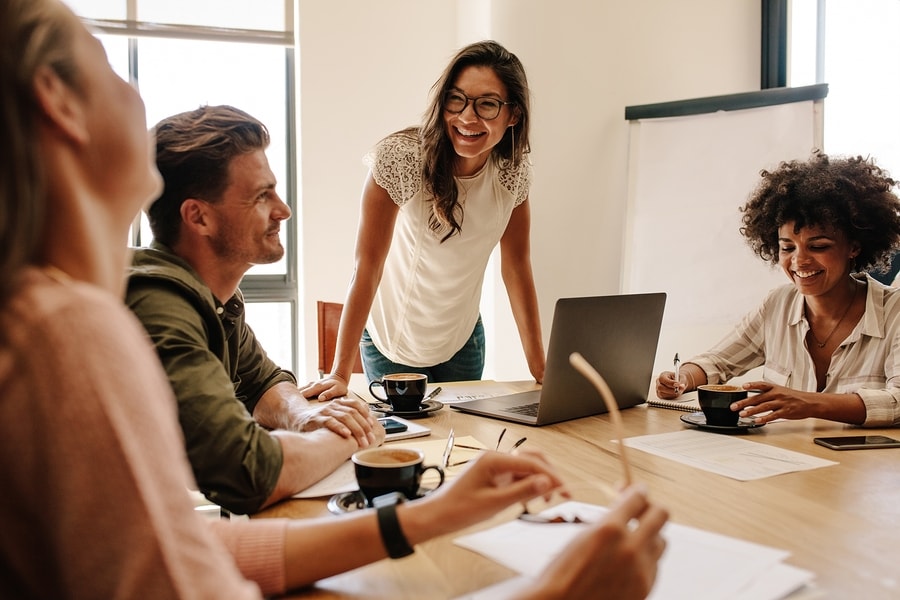 Vrouw is 13 weken zwanger en verteld lachend aan haar collega's op werk dat ze zwanger is