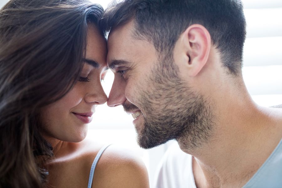 Man kijkt vrouw die 42 weken zwanger is liefdevol aan
