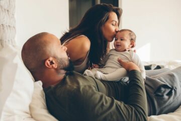 Vader en moeder gaan ouderschapsverlof regelen voor pasgeboren baby en knuffelen samen de baby