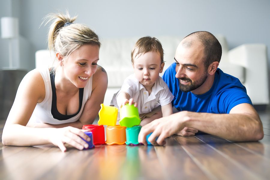 Vader, moeder en baby van 23 maanden oud bouwen samen een blokkentoren