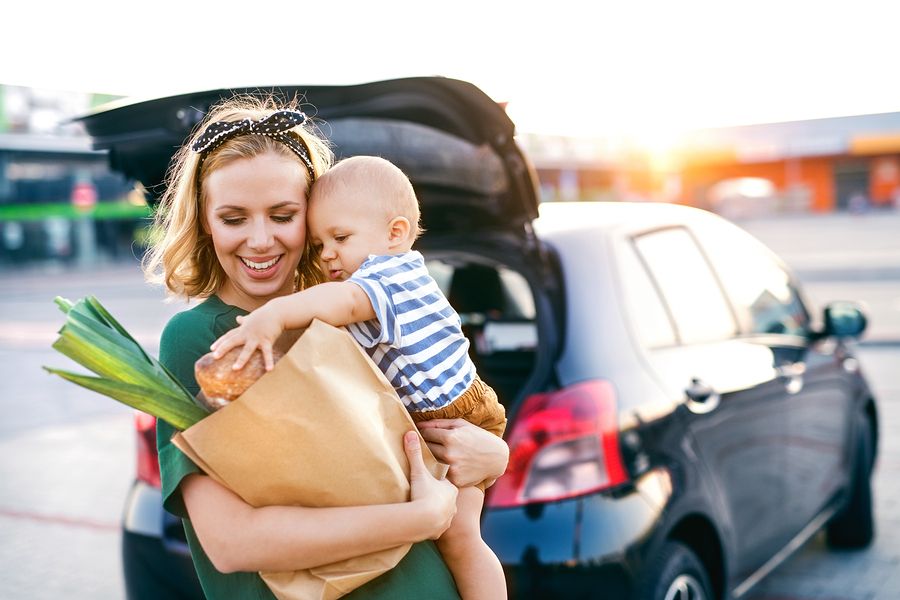 Moeder doet boodschappen met baby van 24 weken oud