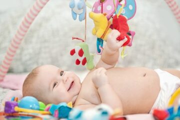 Baby ligt op een babygym