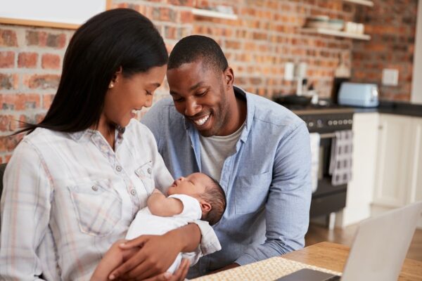 Vader en moeder kijken verliefd naar hun baby