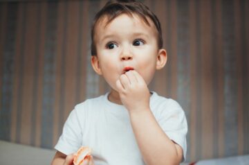 Peuter snoept van gezonde snack: een mandarijntje