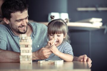 Papa en peuter spelen samen spelletje als beloning