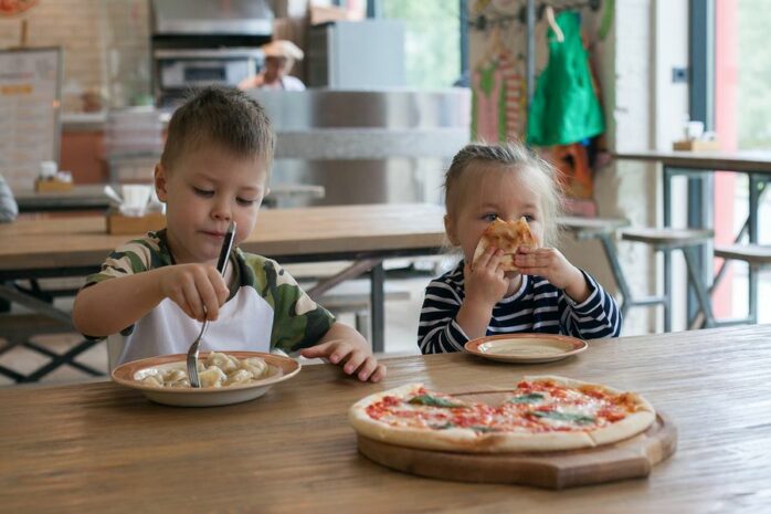 Peuters eten pizza in restaurant