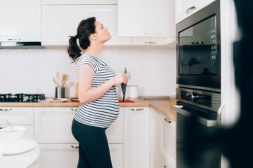 Zwangere vrouw kijkt naar oven