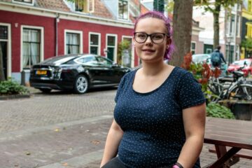 Tienermoeder Sterre op een bankje voor de deur van een woonhuis