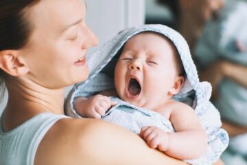 gapende baby ingesmeerd met verzorgingsproducten