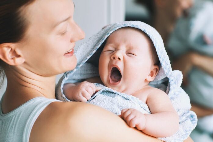 gapende baby ingesmeerd met verzorgingsproducten