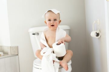 Kind speelt met wc-papier op de wc