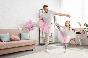 Vader en dochter doen samen aan ballet in de woonkamer