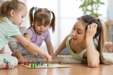 Moeder en peuters spelen bordspelletje