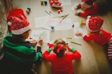 Vader ligt tijdens feestdagen met kinderen kerstknutsels te maken,