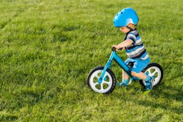 Peuter op een blauw loopfietsje