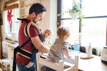 Vader speelt peuterspelletje afwassen met zoon