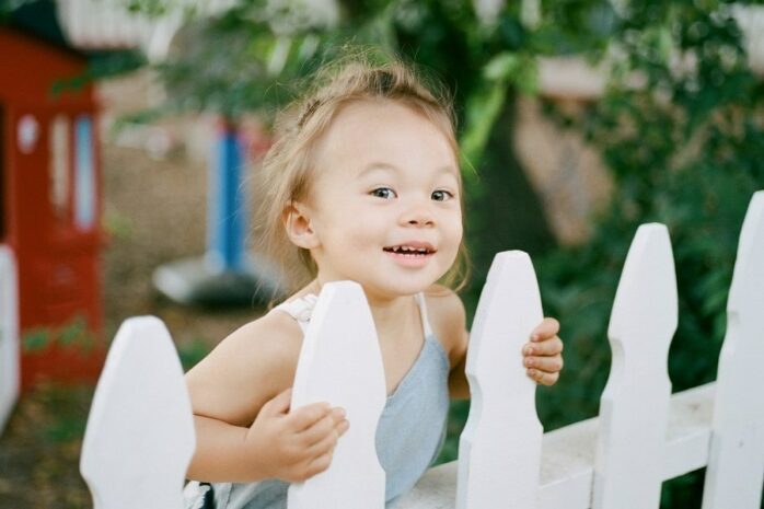 Meisje bij hek als peuterspelletje