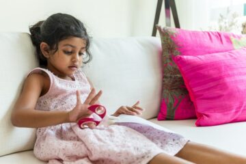 Meisje knipt met kinderschaar als peuterspelletje