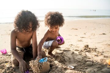 Peuters zoeken schatten op strand als peuterspelletje