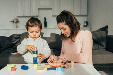 Moeder en zoon bouwen toren als peuterspelletje