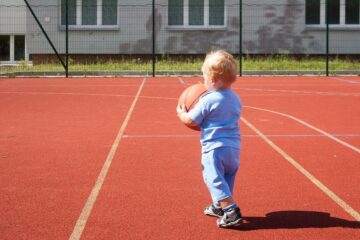 Peuter speelt het peuterspelletje basketbal