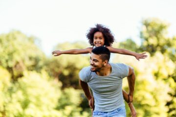 Vader draagt hypermobiel kind op zijn rug