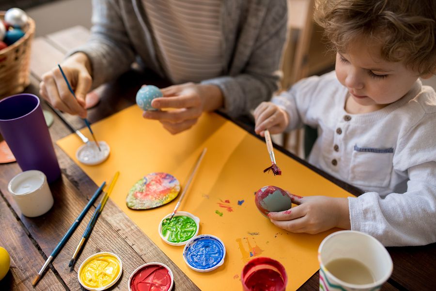 Kind van 2 jaar is met moeder aan het knutselen, ze verven stenen