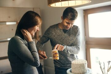 Aanstaande vader en moeder snijden gender reveal taart aan