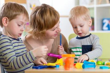 Moeder en kinderen spelen samen peuterspelletjes