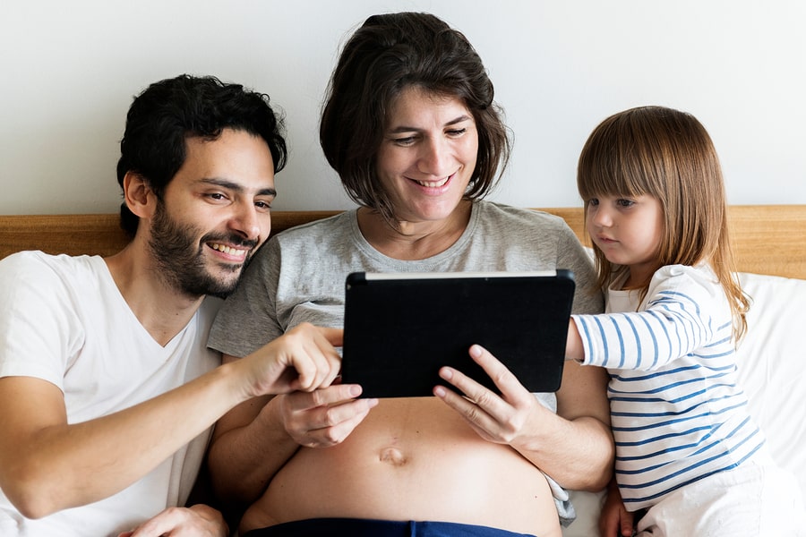 Vader, peuter en zwangere vrouw downloaden de 24Baby zwangerschaps app