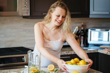 Zwangere vrouw snijdt citroenen om de juiste zwangerschapsvitamines binnen te krijgen