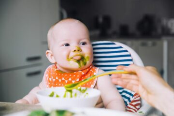 Baby eet spinaziehapje om voldoende vitamines binnen te krijgen