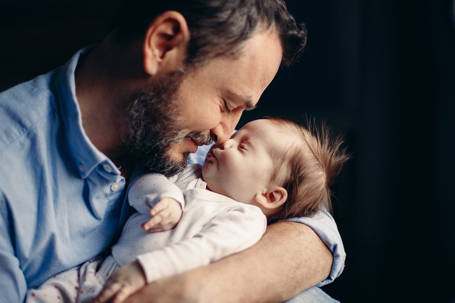 Man knuffelt zijn pasgeboren baby