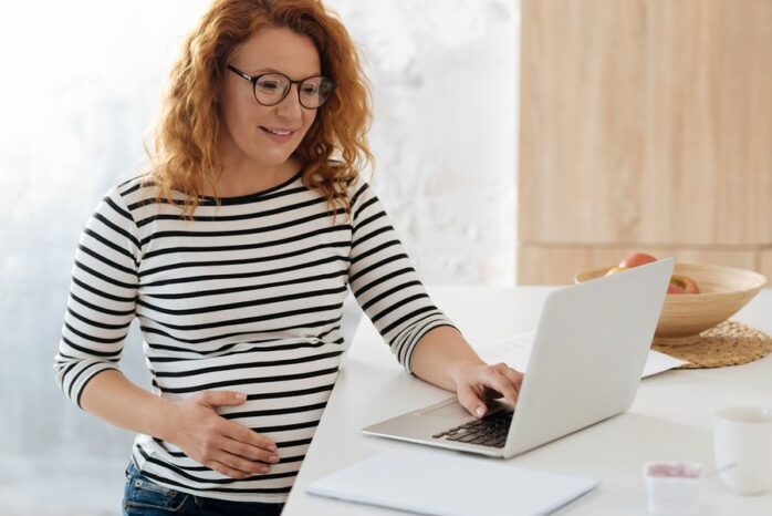 Zwangere vrouw vult Checklist in op haar laptop